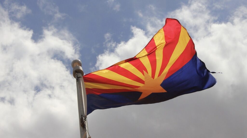 Arizona State Flag. It consists of 13 rays of red & weld-yellow on the top half.