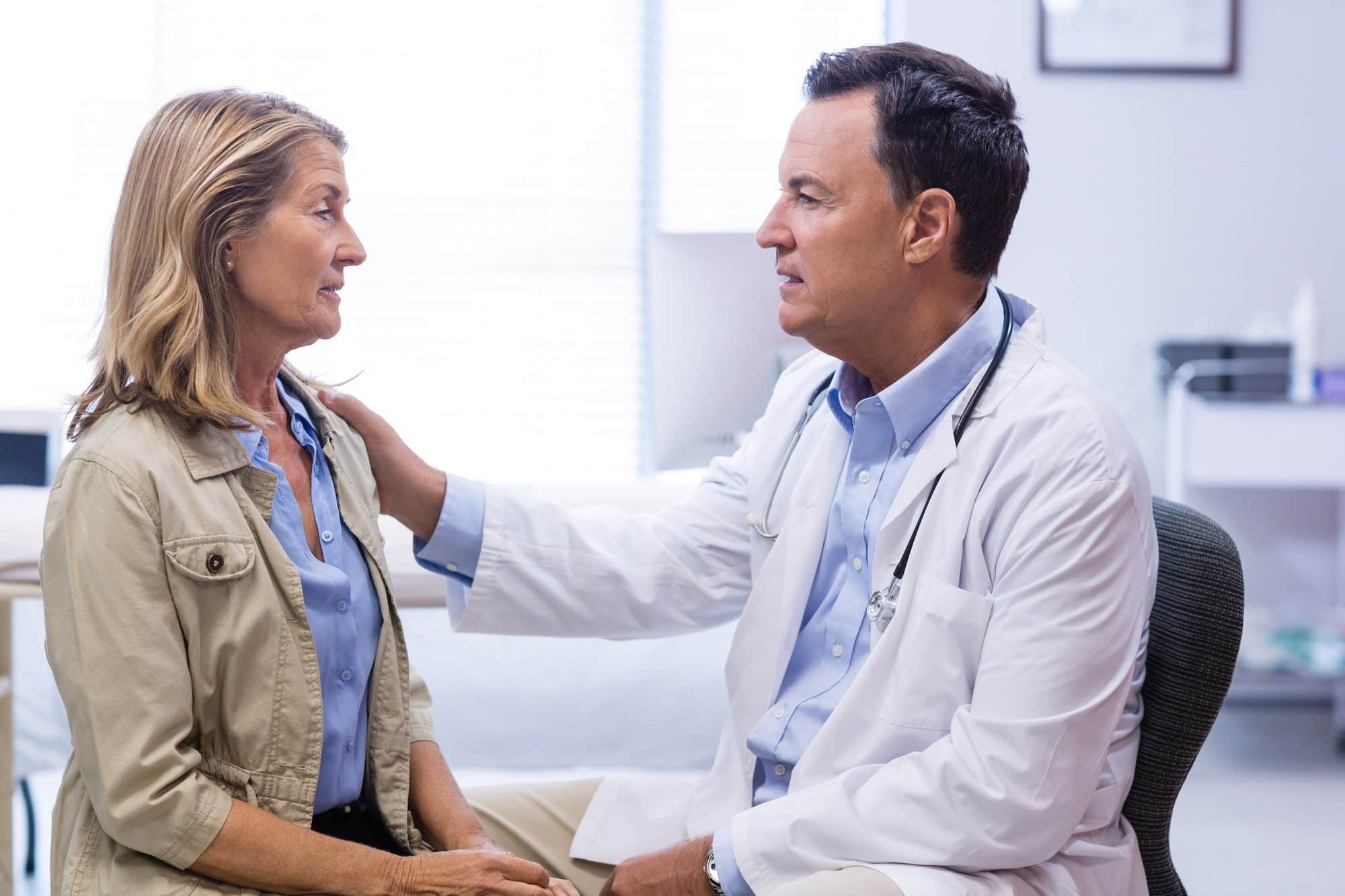 Doctor consoling senior woman