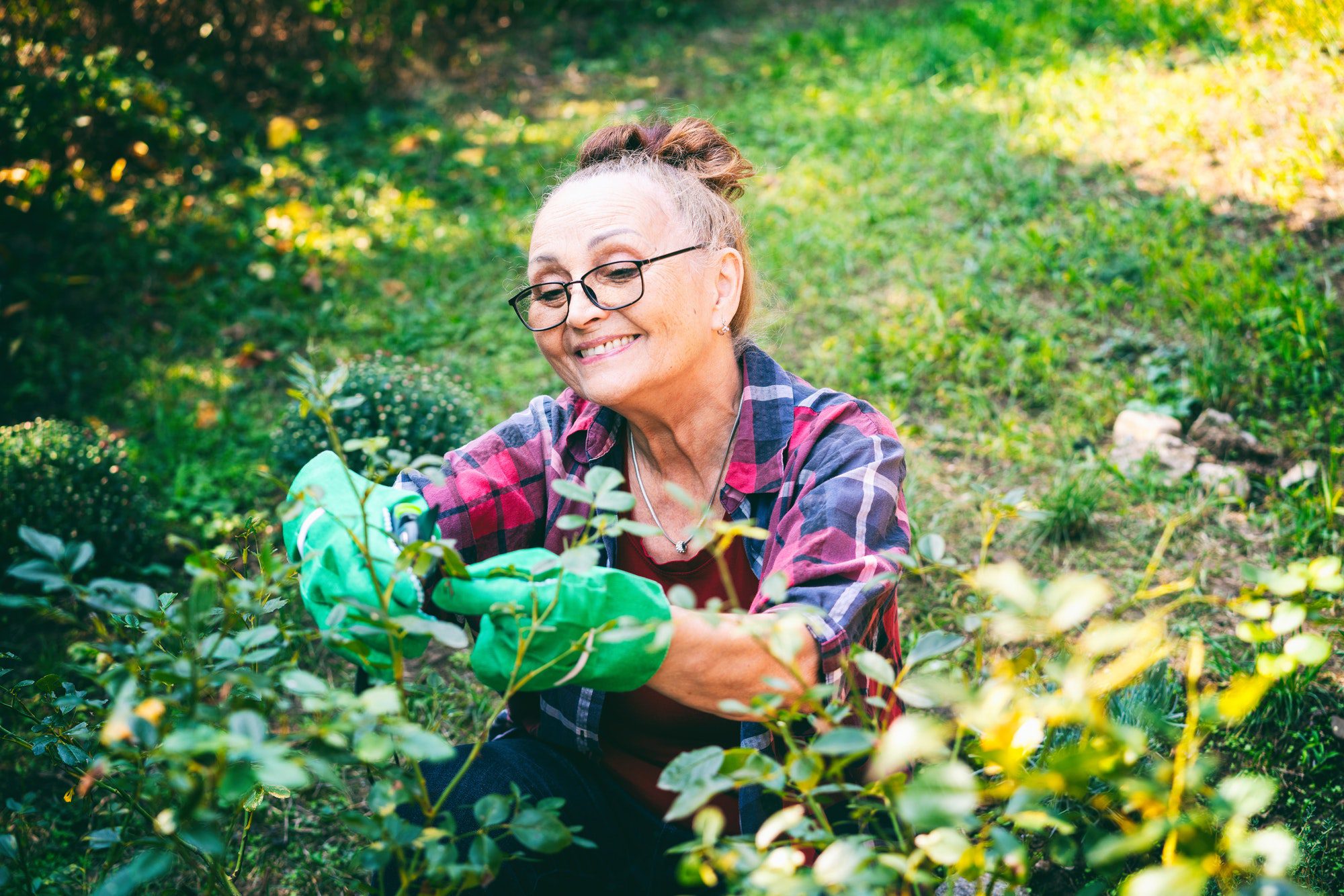 Happy senior woman gardening as she thinks over Medigap Plan J.