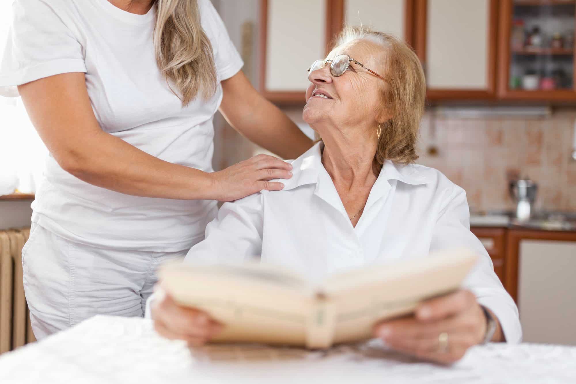 Elderly lady with her care giver as they discuss medicare being primary insurance.