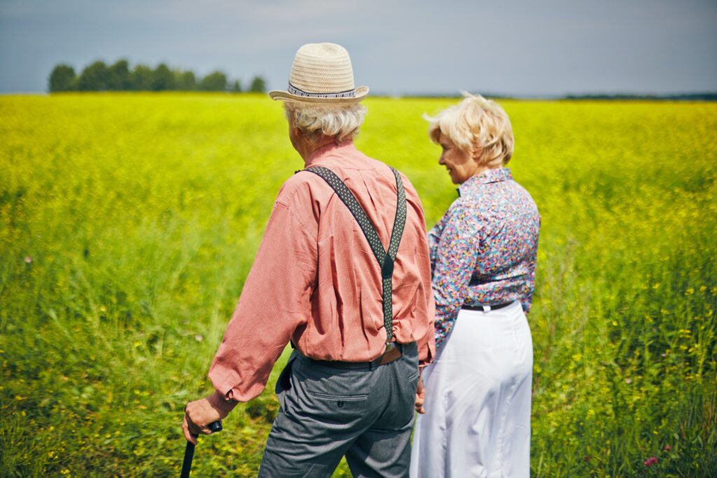 Senior couple admiring a green field as they discuss Medicare Advantage