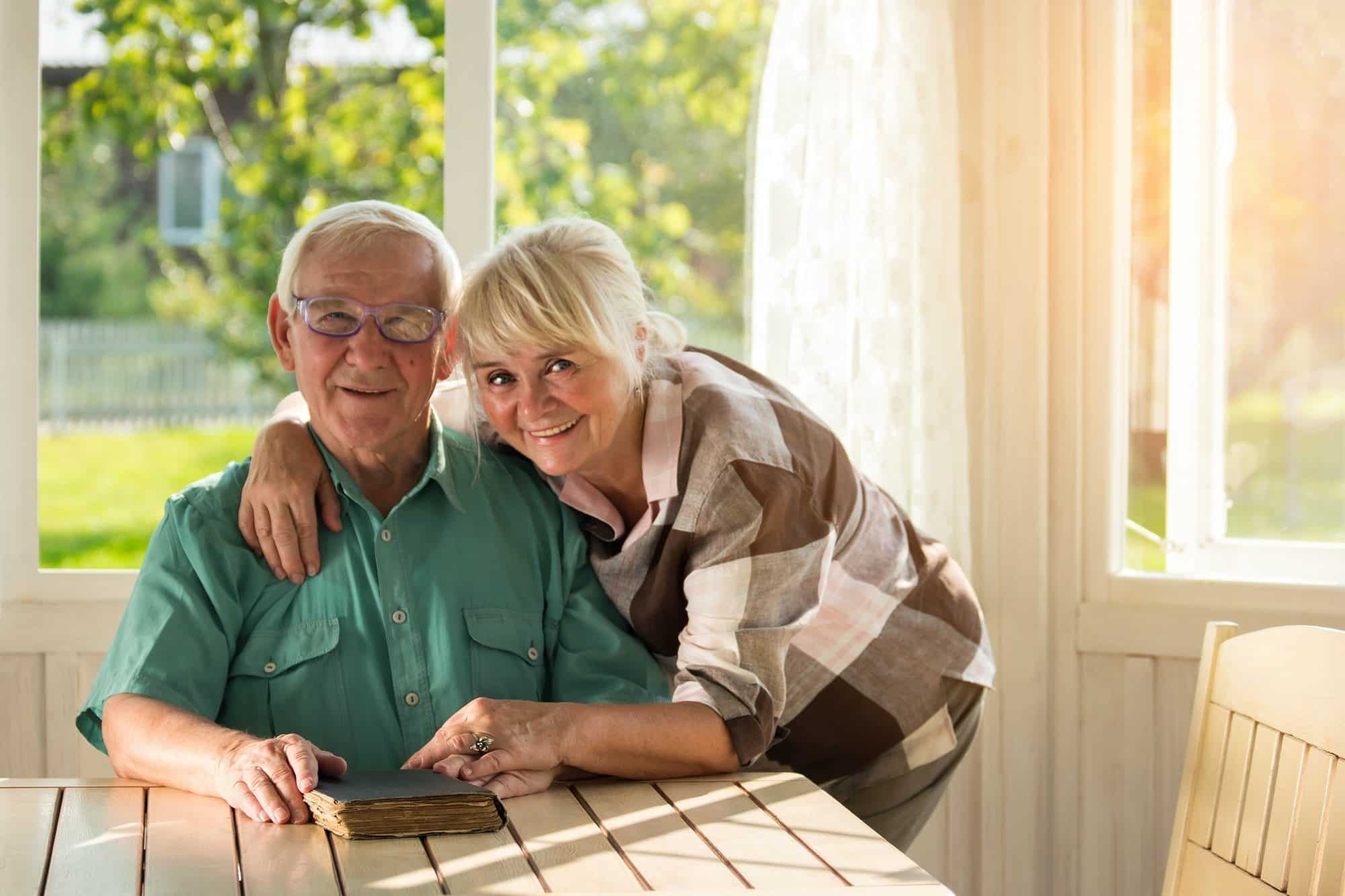 Senior couple reading book about the pros and cons of high deductible plan g.