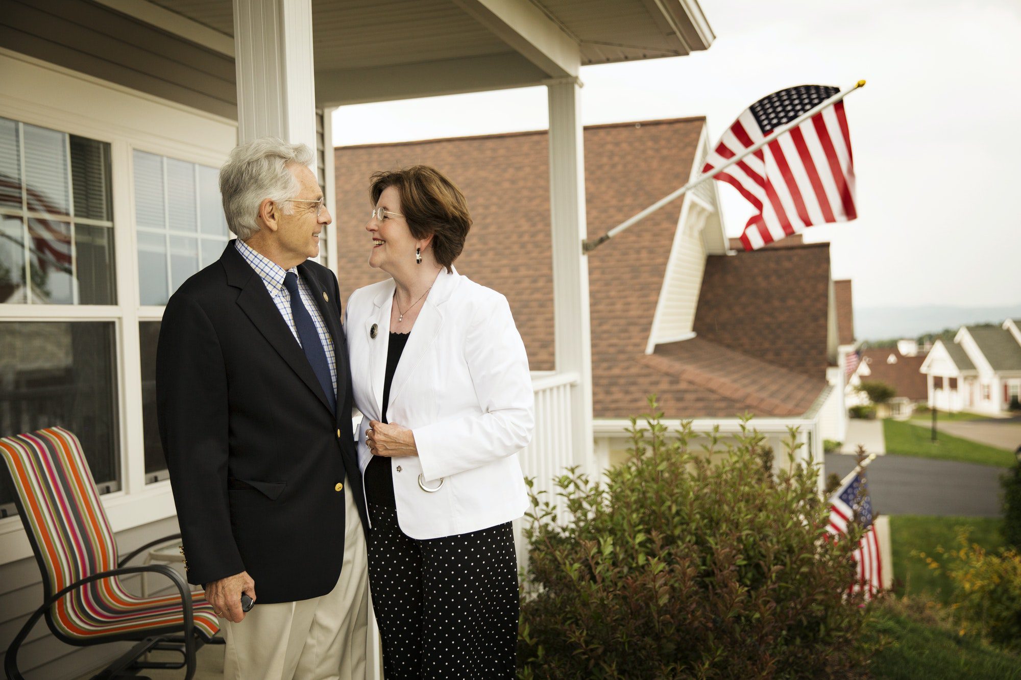 Senior Couple Standing On Porch as they discuss the basics of medicare.