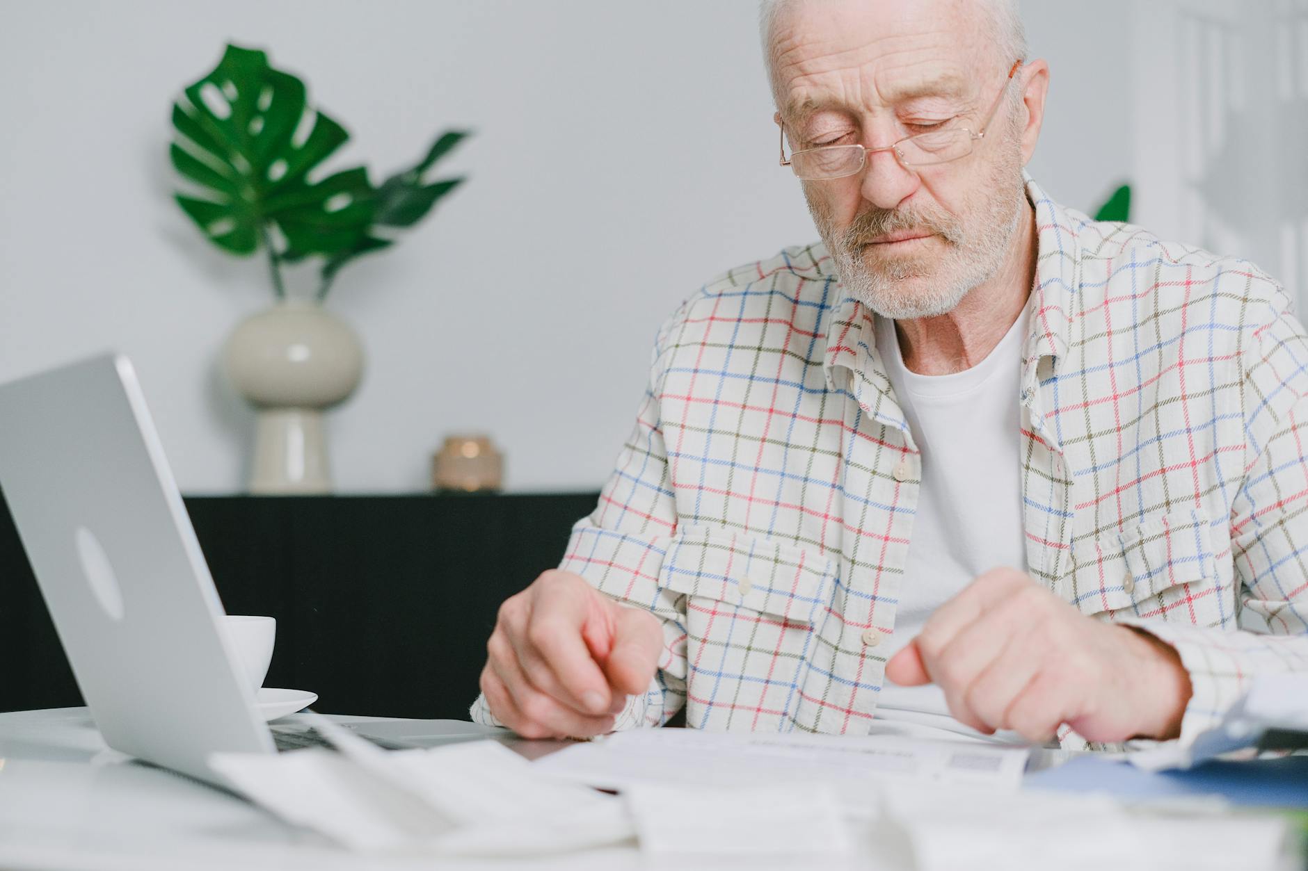 Houston couple in their early 60s sitting at the kitchen table reviewing health insurance paperwork while planning their bridge from ACA Marketplace coverage to Medicare at 65.