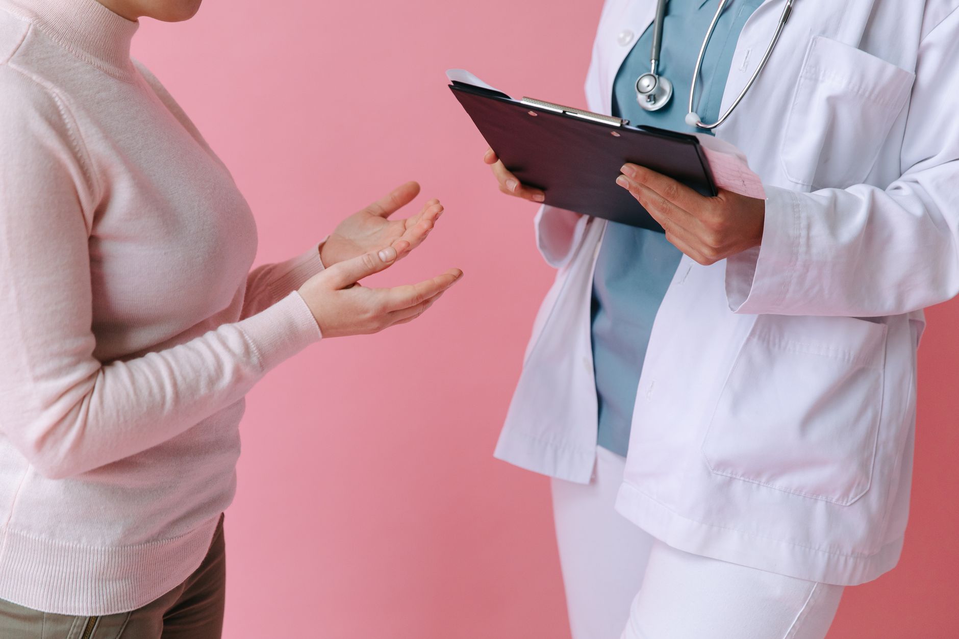 A Houston patient talks with a clinician who is holding a clipboard — the moment when whether your plan has a provider network starts to matter.