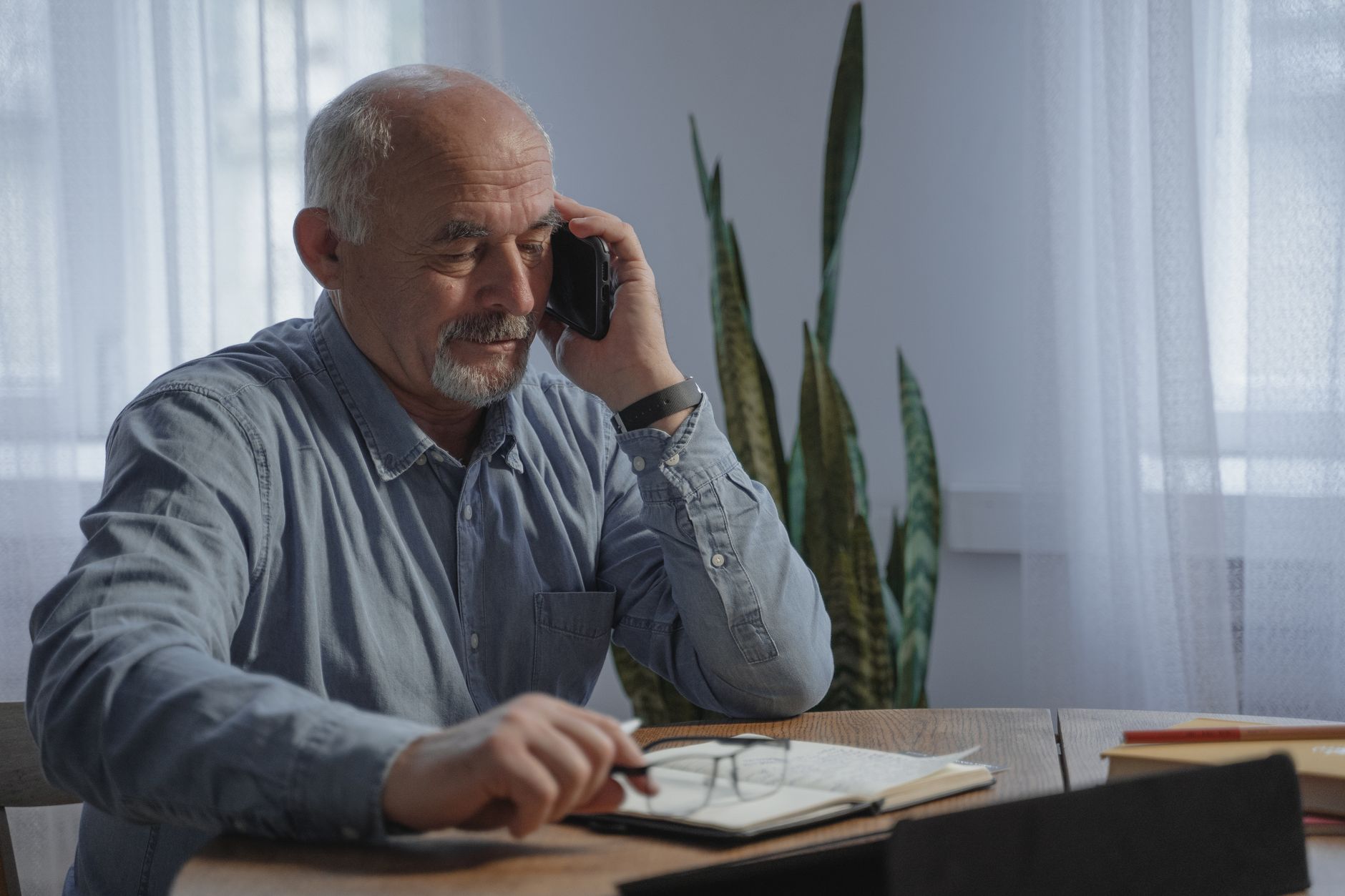 An older adult fills a weekly pill organizer at home — the routine a Part D plan non-renewal interrupts.